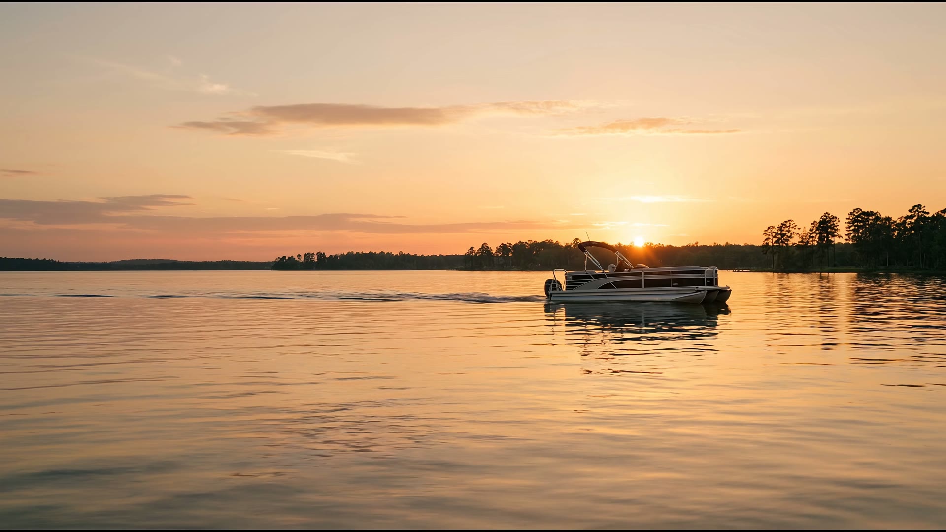 Tritoon cruising glassy Lake Conroe water at golden hour
