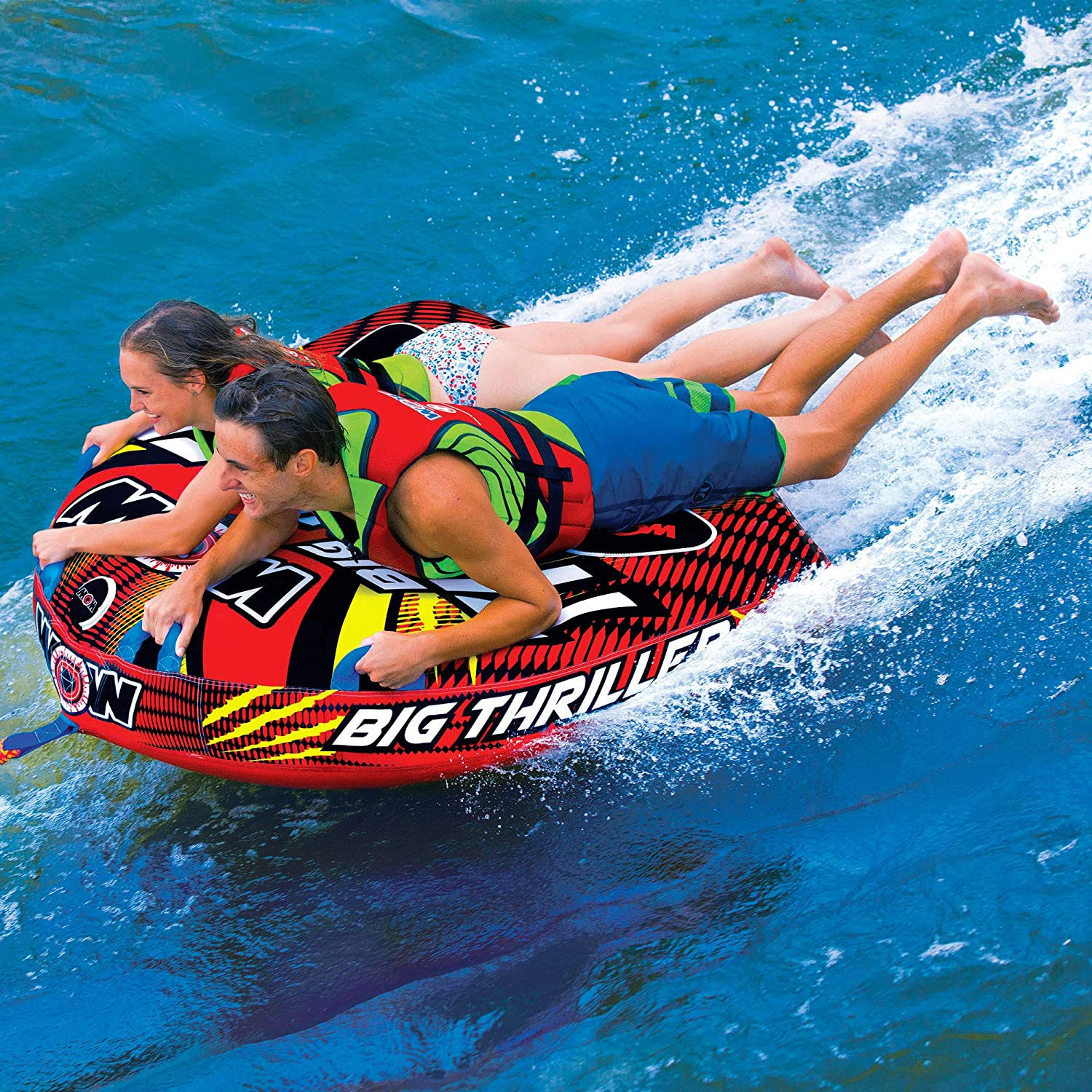 Two riders holding on tight to the ski tube