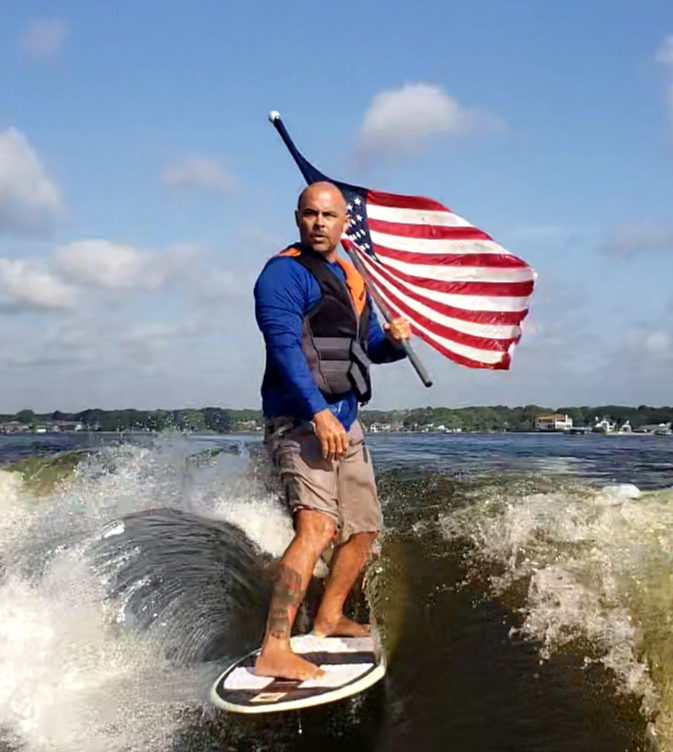Wake surfer riding with the American flag